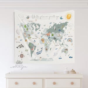 Pode incluir: Uma tape&ccedil;aria de mapa-m&uacute;ndi branca com um esquema de cores azul claro e verde. O mapa apresenta ilustra&ccedil;&otilde;es de animais, marcos e o texto "Oh the places you'll go". Um sol, um bal&atilde;o de ar quente e uma b&uacute;ssola tamb&eacute;m est&atilde;o inclu&iacute;dos.