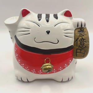 Japoński ceramiczny banknot Maneki Neko. Przechowuj monety lub losy na loterię — to doskonałe rozwiązanie, jeśli chcesz przyciągnąć szczęście i pomyślność do swojego domu.