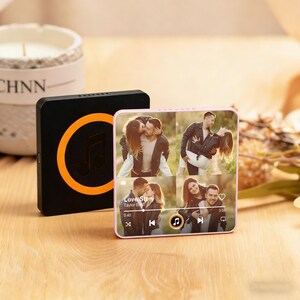 May include: A black and orange music player with a circular design and a music note icon. Next to it is a pink music player displaying a photo collage and a music player interface. The song title is "Love Story".
