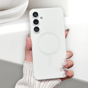 May include: A white phone case featuring a circular design and a vertical rectangle at the base. The case has three camera lenses and a flash. The phone case is held by a person.
