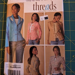 May include: Simplicity Threads magazine collection sewing pattern. The pattern features images of women wearing various jackets. The pattern size is R5, with sizes 14, 16, 18, 20, and 22. The pattern includes the text "Step by step to sewing success!"