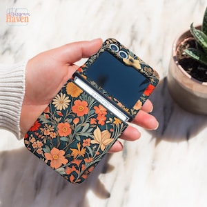 May include: A Samsung flip phone case featuring a floral design in shades of orange, yellow, and cream against a dark teal backdrop. The case is open, displaying the phone's screen and the Samsung logo. The Hologram Haven logo is visible.
