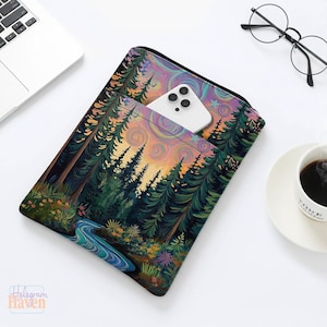 May include: A laptop sleeve featuring a vibrant forest scene with a river, trees, and a colorful sky. A white smartphone is in the front pocket. The sleeve is on a white surface with a laptop, glasses, and a coffee cup.