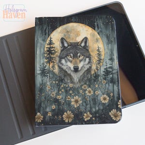 May include: A tablet case featuring a wolf illustration. The design includes a full moon, pine trees, and wildflowers in a forest setting. The wolf has yellow eyes and is centered on the case. The case is black and gray.