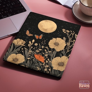 Può includere: Custodia nera per laptop con un design floreale e a farfalla sotto una luna piena. L'opera d'arte comprende grandi fiori beige, papaveri arancioni e due farfalle. La custodia è progettata per un laptop.