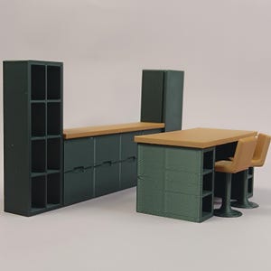 Op de afbeelding: Miniatuurkeuken met donkergroene kasten, een lichtbruin aanrechtblad en een bijpassende tafel met twee stoelen. De set bevat een kast met open schappen en een koelkast.