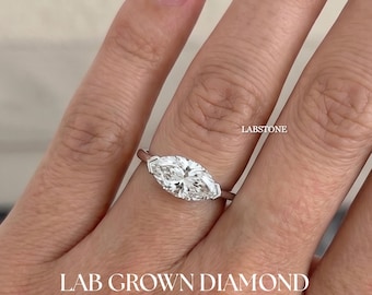 May include: A marquise-cut lab-grown diamond ring with a silver band. The ring features a large, clear, and sparkling diamond. The text "LAB GROWN DIAMOND" is displayed at the bottom of the image.