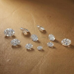 Oval cut lab grown diamonds arranged by size from small to large, diamond size comparison for custom engagement ring selection and jewelry making
