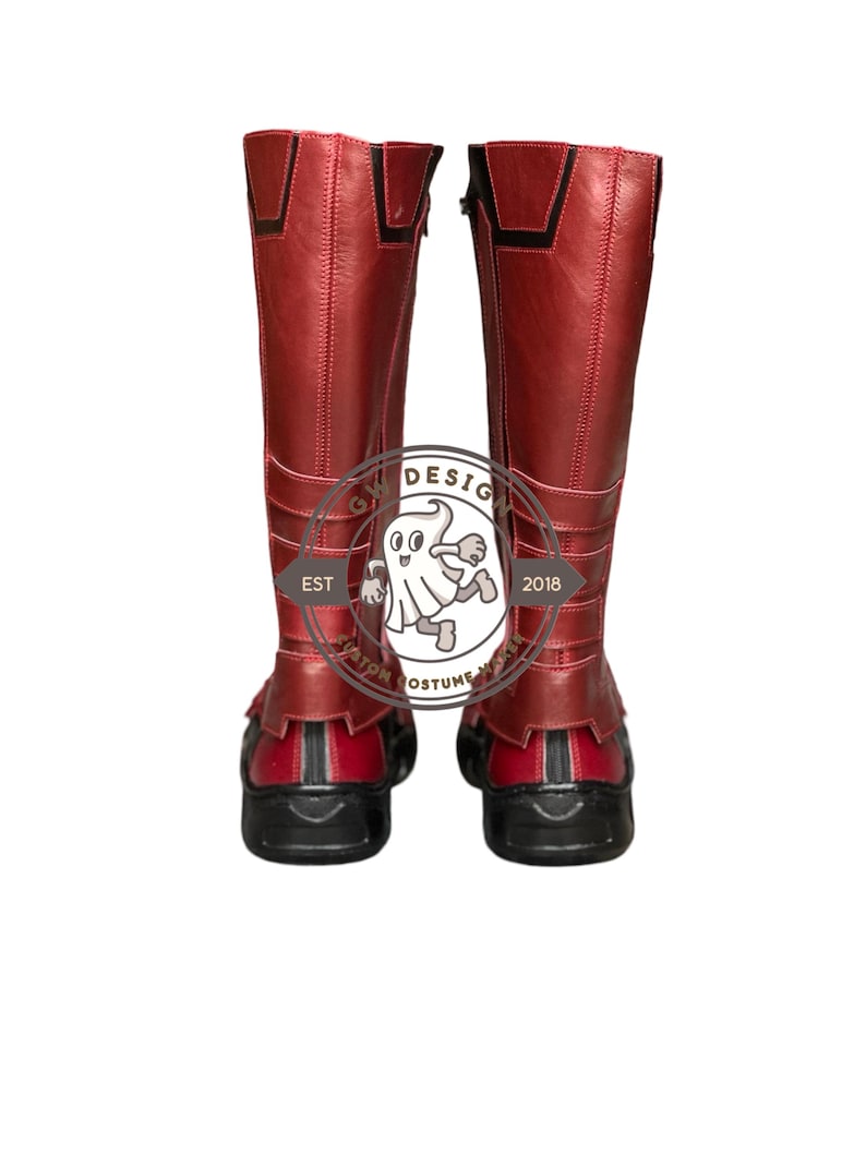 Peut inclure: Une paire de bottes rouges hautes avec des d&eacute;tails noirs. Les bottes montent jusqu'au genou et ont une fermeture &eacute;clair lat&eacute;rale. Les semelles sont noires. Les bottes semblent &ecirc;tre en cuir ou dans une mati&egrave;re similaire. Elles font partie d'un costume.
