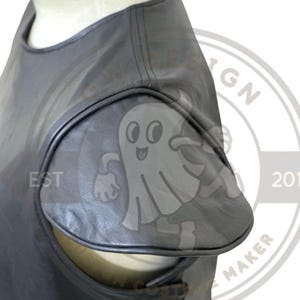 May include: Close-up of a gray, sleeveless top with a unique cut-out design on the shoulder. The top is made of a smooth, possibly leather-like material. The design includes a ghost-like logo.