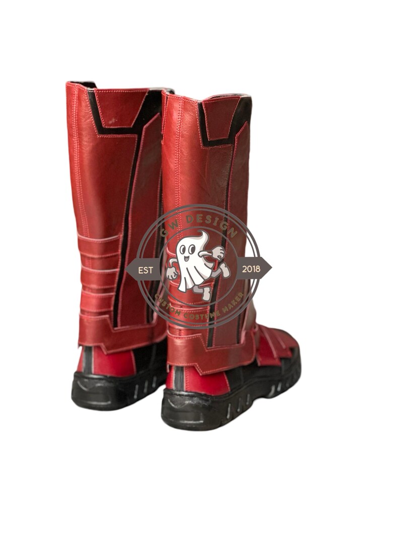 Peut inclure: Une paire de bottes de costume rouges et noires. Les bottes montent jusqu'aux genoux avec une tige rouge textur&eacute;e et des accents noirs. Les semelles sont noires. Les bottes ont un design qui comprend une sangle et une boucle. Fabriqu&eacute; par un fabricant de costumes.
