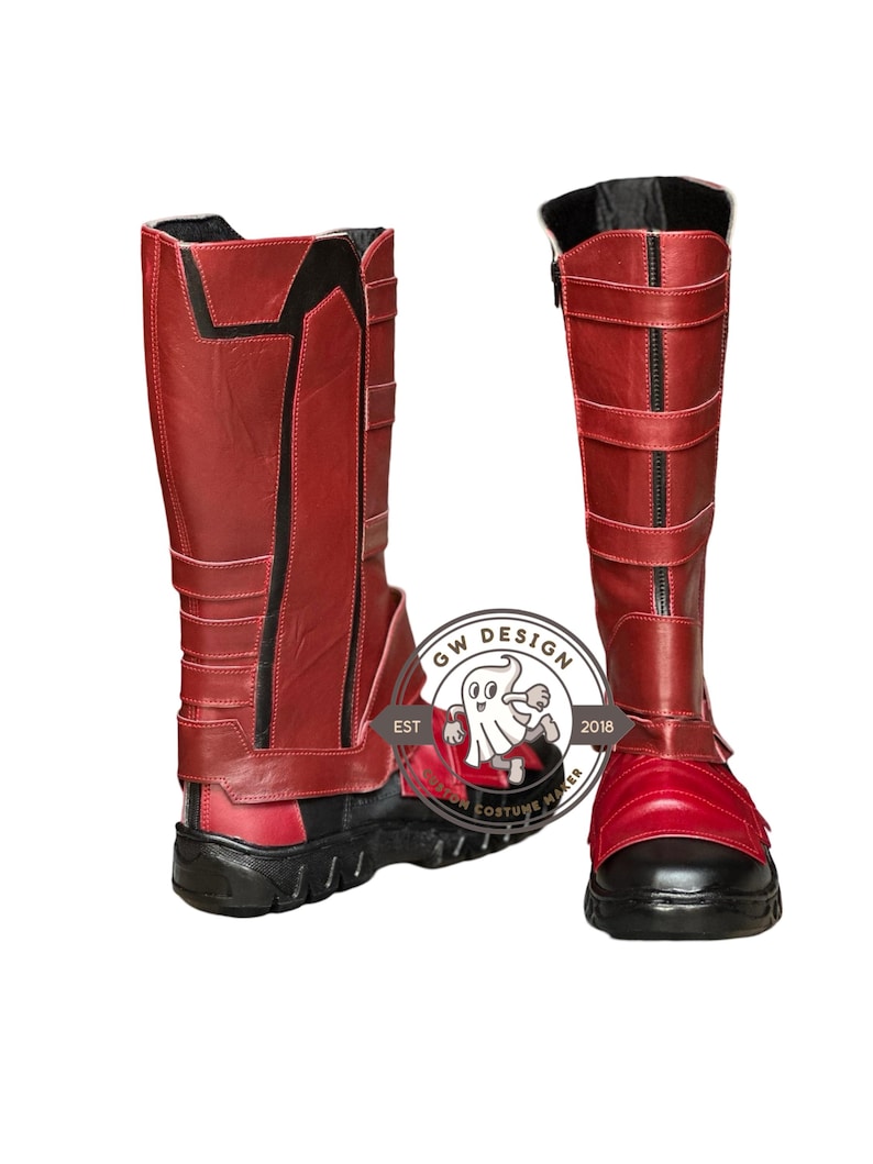 Peut inclure: Une paire de bottes rouges et noires, hautes jusqu'aux genoux. Les bottes ont une fermeture &eacute;clair, des sangles et une semelle noire. Le design comprend des accents noirs et un logo "GW DESIGN COSTUME MAKER EST 2018".
