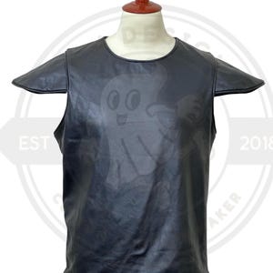 May include: Black leather top with a round neckline and short sleeves. A cartoon ghost graphic is subtly printed on the front. The top is displayed on a mannequin.