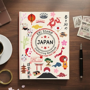 May include: A cream-colored "Eki Stamp Japan Collecting Notebook" with Japanese-themed illustrations. The cover features a red circle with "Japan" and stars, plus images of a dragon, Mount Fuji, and a geisha. A cup of coffee, a magnifying glass, and a pen are also visible.