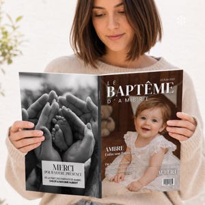 May include: A printed booklet titled Le Baptême d'Ambre featuring a black and white photo of hands holding baby feet on the left cover and a color photo of a baby in a white dress on the right cover with text including 13 Juin 2027 and Aubert.