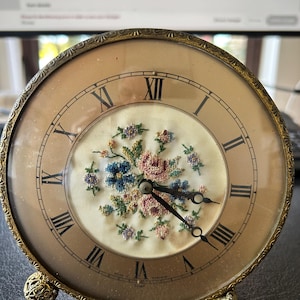 May include: A white ceramic mug with a black handle and the text "But First, Coffee" in a black, bold font. The mug is on a white surface. The mug appears to be empty.