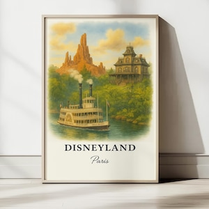 Op de afbeelding: Ingelijste kunstprint van Disneyland Parijs. Het kunstwerk toont een raderstoomboot op een rivier, een berg en een spookhuis. De print heeft een vintage stijl met de woorden "Disneyland Paris" onderaan.