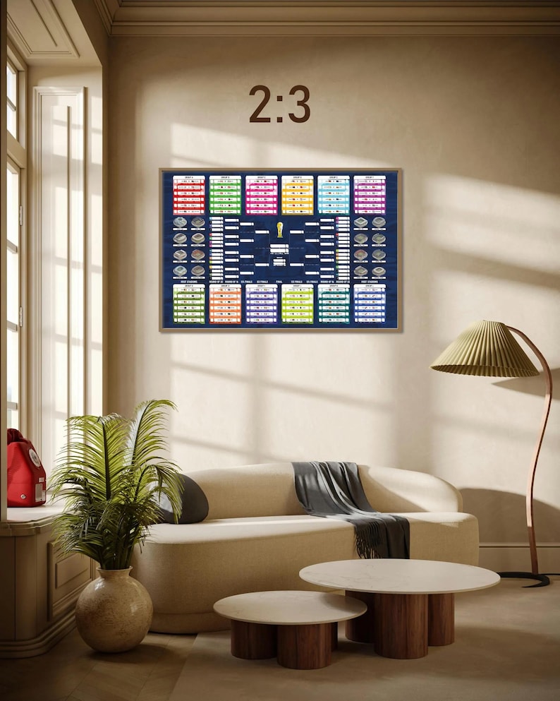 May include: A rectangular wall poster featuring a dark blue FIFA World Cup tournament bracket with colorful group stage boxes, stadium illustrations, and a central gold trophy icon. The text 2:3 is displayed in brown above the framed wall art.