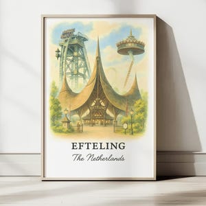 Op de afbeelding: Ingelijste aquarelprint van Efteling, een Nederlands themapark. De afbeelding toont een groot, gedetailleerd gebouw met een uniek dakontwerp, achtbanen en een toren. De tekst "Efteling The Netherlands" staat onderaan.