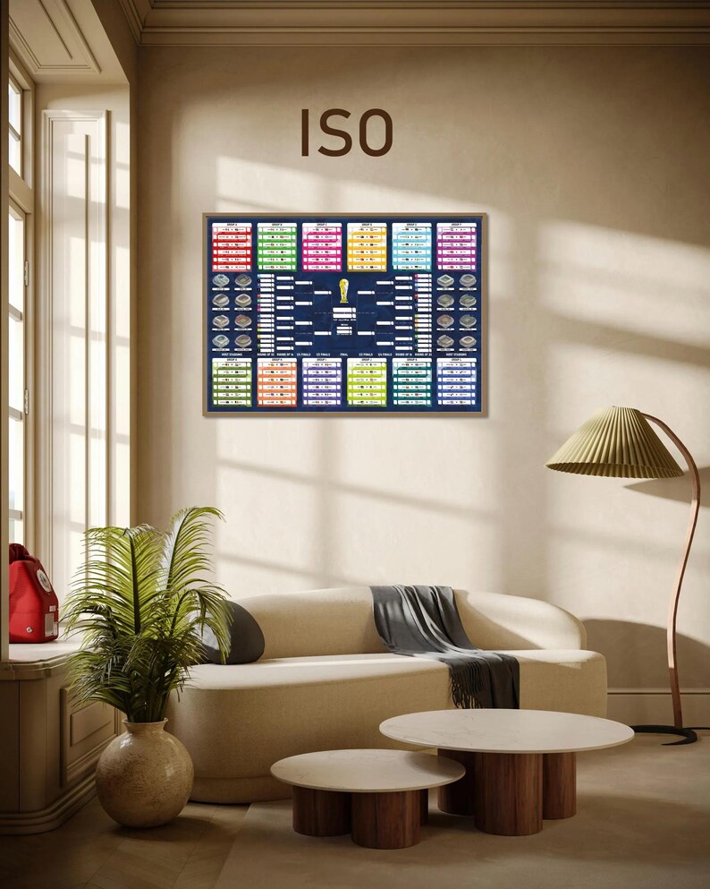 May include: A rectangular wall poster featuring a dark blue FIFA World Cup tournament bracket chart with colorful group stage boxes, a central gold trophy icon, and the text ISO at the top, displayed in a thin wooden frame on a neutral wall.