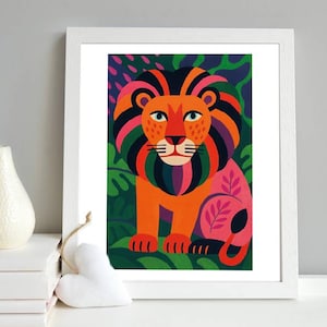 Op de afbeelding: Een ingelijste kunstdruk met een kleurrijke illustratie van een leeuw. De leeuw heeft een oranje lichaam, een veelkleurige manen en staat tegen een achtergrond van groen gebladerte. Het kunstwerk zit in een witte lijst.