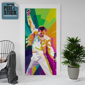 Op de afbeelding: Een kleurrijke deurwrap in pop-artstijl met een portret van een man in een witte outfit met zijn vuist omhoog. De achtergrond is een mix van groen, geel en paars. De tekst "PEEL & STICK" is zichtbaar.