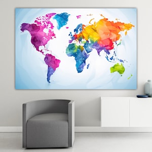 Könnte beinhalten: Ein farbenfrohes Weltkarten-Poster mit geometrischem Design. Die Kontinente sind in einem Mosaik aus Farben wie Rosa, Blau, Gelb, Grün und Orange dargestellt. Der Hintergrund ist ein hellblauer Farbverlauf. Das Poster wird an einer weißen Wand präsentiert.