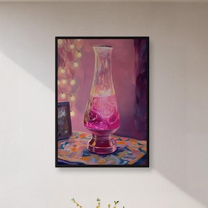 May include: A framed painting of a lava lamp with pink liquid and a red base. The painting is on a wall above a small table and two chairs. The chairs have woven backs and seats. A small table holds a vase of yellow flowers and a few pieces of fruit.