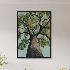May include: A framed art print of a tall tree, viewed from below, with a textured brown trunk and green leaves against a light blue sky. The artwork is displayed in a modern kitchen with light wood cabinets and a marble countertop.