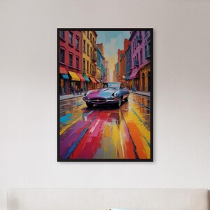May include: A framed art print depicting a classic car on a colorful, wet street. The artwork features a vintage car in shades of blue and purple, set against a backdrop of vibrant buildings and a rainbow-colored road. The print is displayed above a bed.