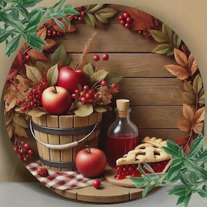 Puede incluir: Naturaleza muerta rústica con un cubo de madera lleno de manzanas rojas y bayas, una botella de vidrio con tapón de corcho y una porción de tarta de cerezas. La escena está dispuesta sobre una superficie redonda de madera con un paño a cuadros rojo y blanco, rodeada de hojas de otoño.