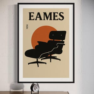 Pode incluir: Impressão de arte emoldurada com uma silhueta preta de uma cadeira Eames contra um fundo bege com um sol laranja. A palavra "EAMES" é impressa em letras grandes e em negrito acima da cadeira, com "1956" impresso verticalmente à esquerda.