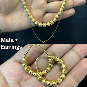 May include: Gold-colored jewelry set featuring a beaded necklace and hoop earrings. The necklace has a delicate chain and the earrings are adorned with matching beaded details. The text "Mala + Earrings" is visible in the image.