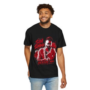 May include: Black t-shirt with a red and white graphic of a man, the text "Sim Simma" and "Beenie Man". The graphic depicts the man in a red jacket and gold chain.