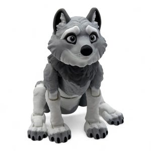 May include: A gray and white wolf figurine with a friendly expression. The wolf has large, expressive eyes, a black nose, and detailed fur texture. The figurine is posed in a seated position, with articulated joints.