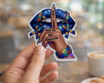 May include: A sticker featuring a blue-toned mouth with a finger pressed to the lips, adorned with puzzle ribbon. The words "DON'T JUDGE" and "WHAT YOU DON'T UNDERSTAND" are printed on the image. A puzzle piece bracelet is also visible.