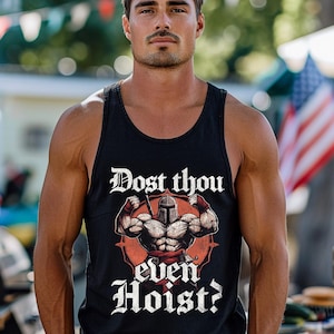 K&ouml;nnte beinhalten: Schwarzes Tanktop mit dem Text "Dost thou even Hoist?" und einer Grafik eines muskul&ouml;sen Ritters. Das Design ist in Wei&szlig; und Rot gehalten. Das Tanktop ist &auml;rmellos.