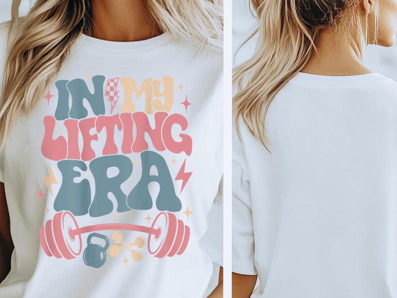 May include: White t-shirt with the text "IN MY LIFTING ERA" in retro-style lettering. The design includes a barbell, weights, and lightning bolts in pastel colors. The shirt is a casual wear item.