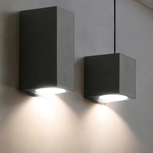Modern handmade ceramic LED wall sconce light. Waterproof up/down cube fixture for stylish indoor lighting. Contemporary decor touch.