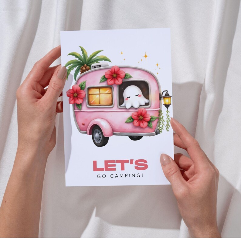 K&ouml;nnte beinhalten: Illustration eines rosa Wohnwagens mit roten Blumen und einem niedlichen Geist im Fenster. Der Text "LET'S GO CAMPING!" ist in Rosa dargestellt. Eine Palme und eine Laterne sind ebenfalls abgebildet.