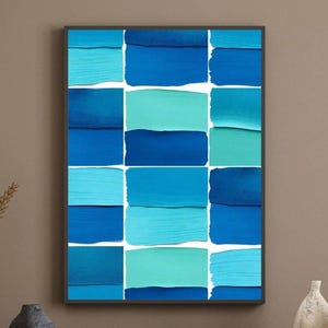 Puede incluir: Una impresión de arte mural rectangular que presenta una cuadrícula de quince muestras de pintura horizontales en varios tonos de azul, incluyendo azul marino, azul real, azul cielo y turquesa, sobre un fondo blanco con un marco negro.