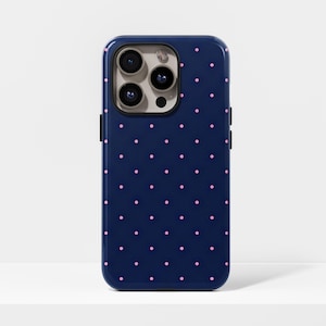 May include: A navy blue phone case adorned with a repeating pattern of small pink polka dots. The case has a glossy finish and a camera cutout with three lenses.