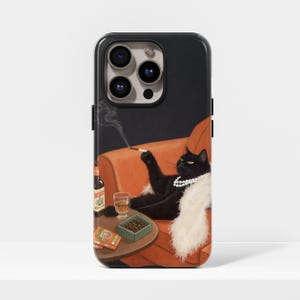May include: Black phone case featuring an illustration of a black cat wearing a pearl necklace and a white fur stole, smoking a cigarette while lounging on an orange armchair. A bottle of beer, a glass of liquor, and a box of chocolates are on the side table.