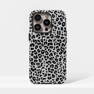May include: A white and black leopard print phone case. The case has a black border and a camera cutout. The leopard print pattern covers the entire back of the phone case. The case is designed to fit a smartphone.