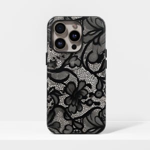 Op de afbeelding: Telefoonhoesje met zwart en wit bloemen kanten design. De hoes heeft een gedetailleerd kanten patroon met donkerzwarte bloemen en een delicate witte achtergrond. De telefoonhoes heeft een glanzende afwerking en een camera-uitsparing.