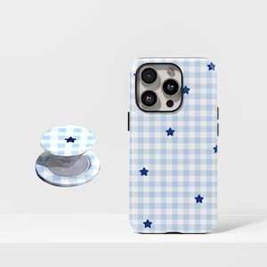 May include: A light blue and white gingham patterned phone case with navy blue star accents. A matching phone grip is also visible. The phone case is designed to fit a smartphone. The phone grip is in the open position.