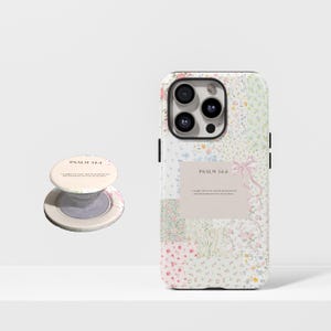 Puede incluir: Una funda de teléfono y un agarre para teléfono con un diseño floral. La funda del teléfono presenta un diseño de patchwork con varios estampados florales pastel. El agarre del teléfono tiene una base blanca con un diseño floral y el texto "PSALM 34:4".