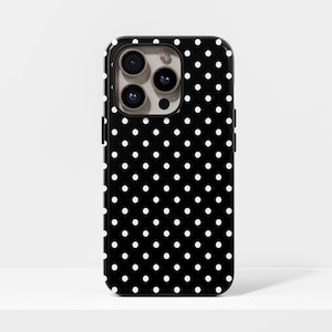 Puede incluir: Funda de teléfono negra con un patrón de lunares blancos. La funda tiene un acabado brillante y un recorte para la cámara. El diseño es un patrón clásico y sencillo, adecuado para varios estilos.