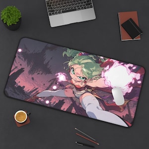 May include: A rectangular desk mat featuring an anime-style illustration of a character with green hair and white thigh-high stockings casting a glowing pink energy orb. The background depicts a dark, ruined landscape under a dusky purple sky.