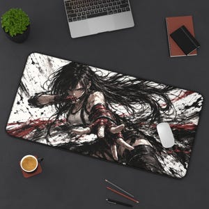 May include: A rectangular desk mat featuring a high-contrast, black and white ink-style illustration of a long-haired character in a dynamic pose. The design includes bold red accents, splattered ink effects, and a white background with dark edges.